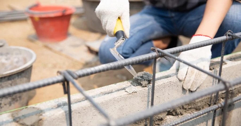 Operaio lavora il cemento, tra i materiali sottoposti al caro materiali