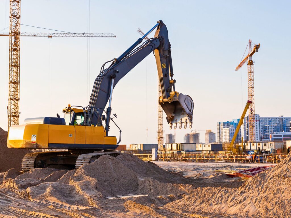 Gru a torre ed escavatore in cantiere